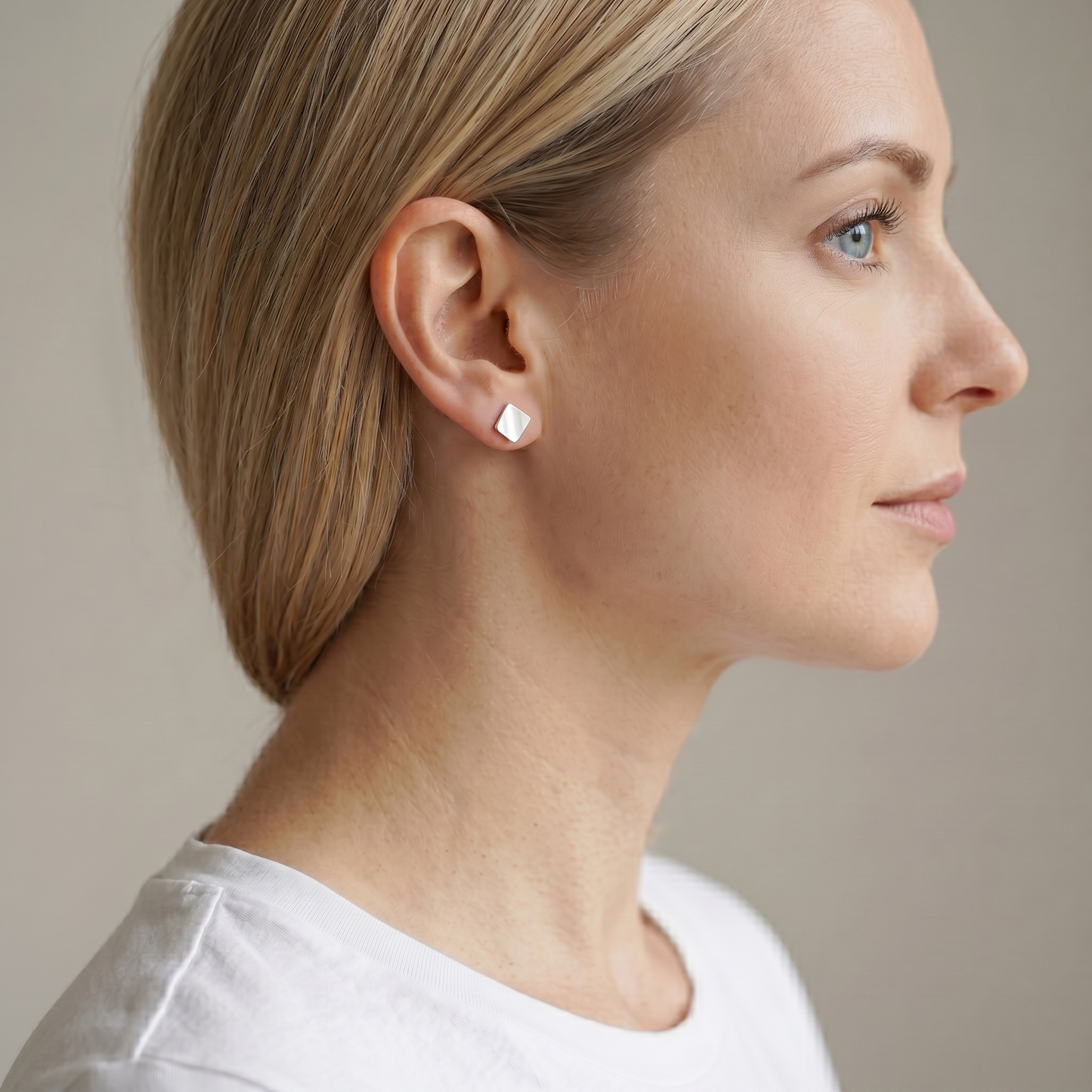 Matte cube stud earrings on a woman, silver-tone square studs at the ear