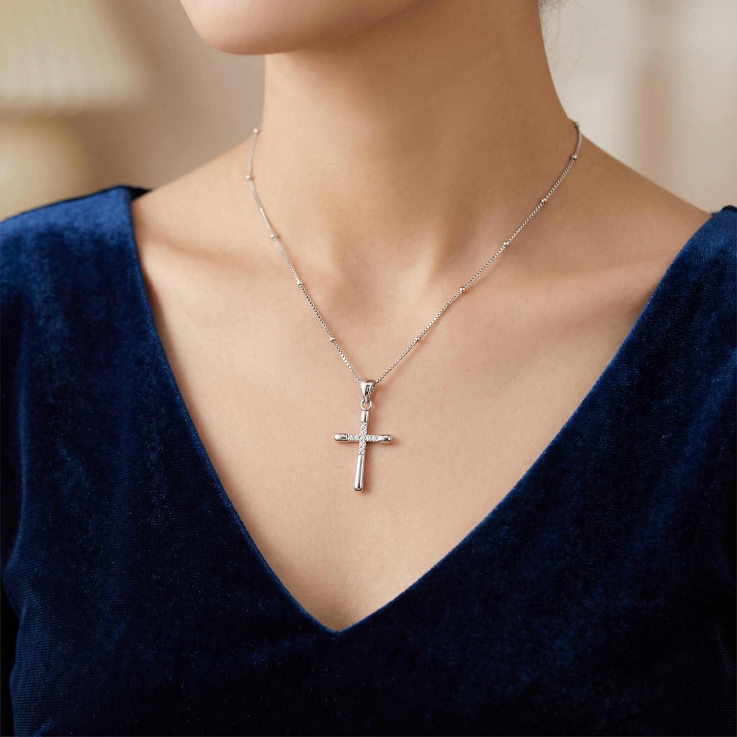 CZ cross pendant on necklace worn on neck, silver-tone cross with CZ stones