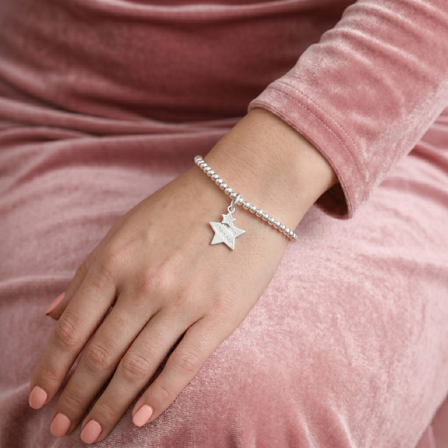 Silver star charm bracelet with bead chain and small star pendant on wrist