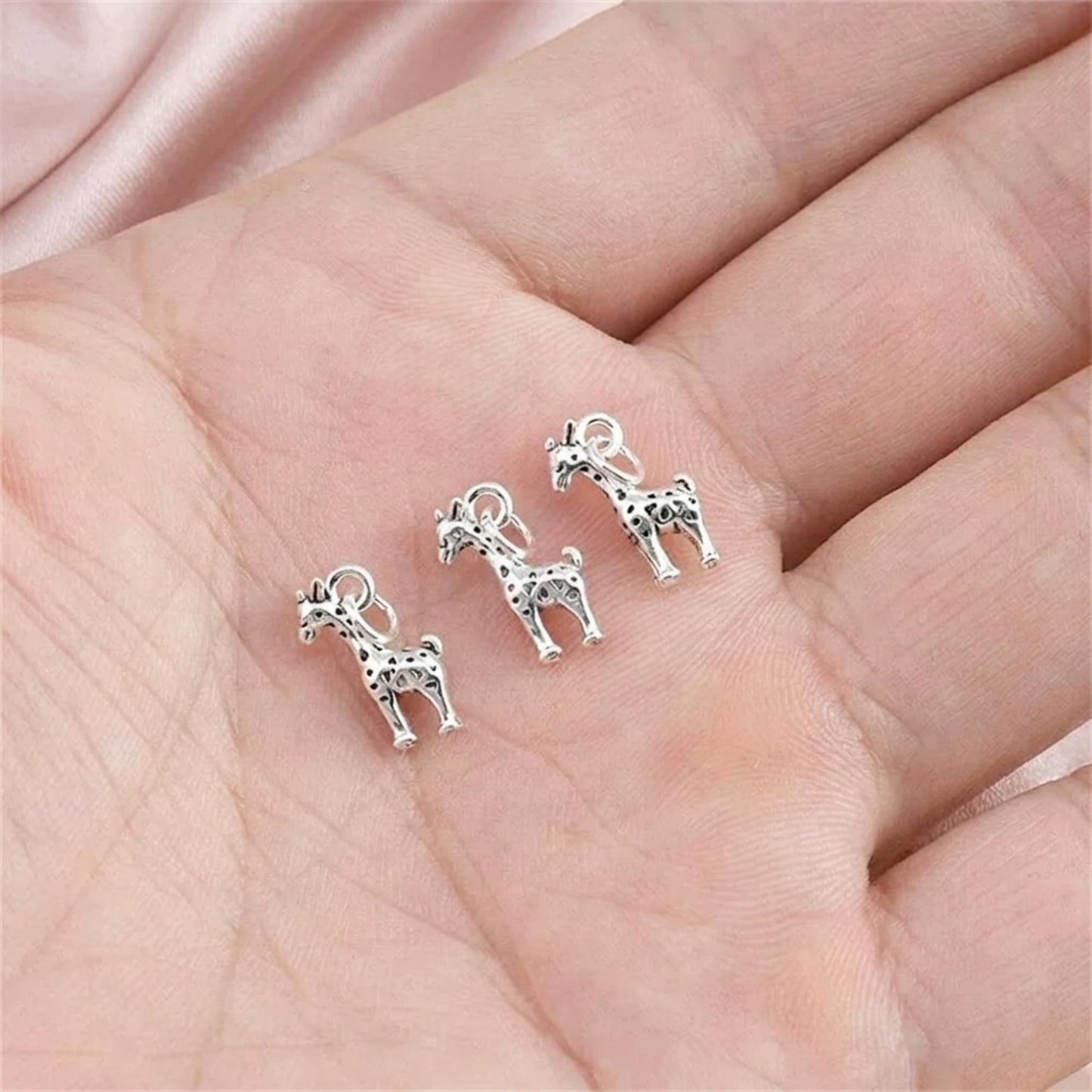 Set of three silver-tone giraffe pendant charms with spotted detailing and loops