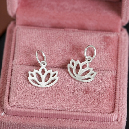 Two silver-toned filigree lotus charm pendants with oval hanging loops