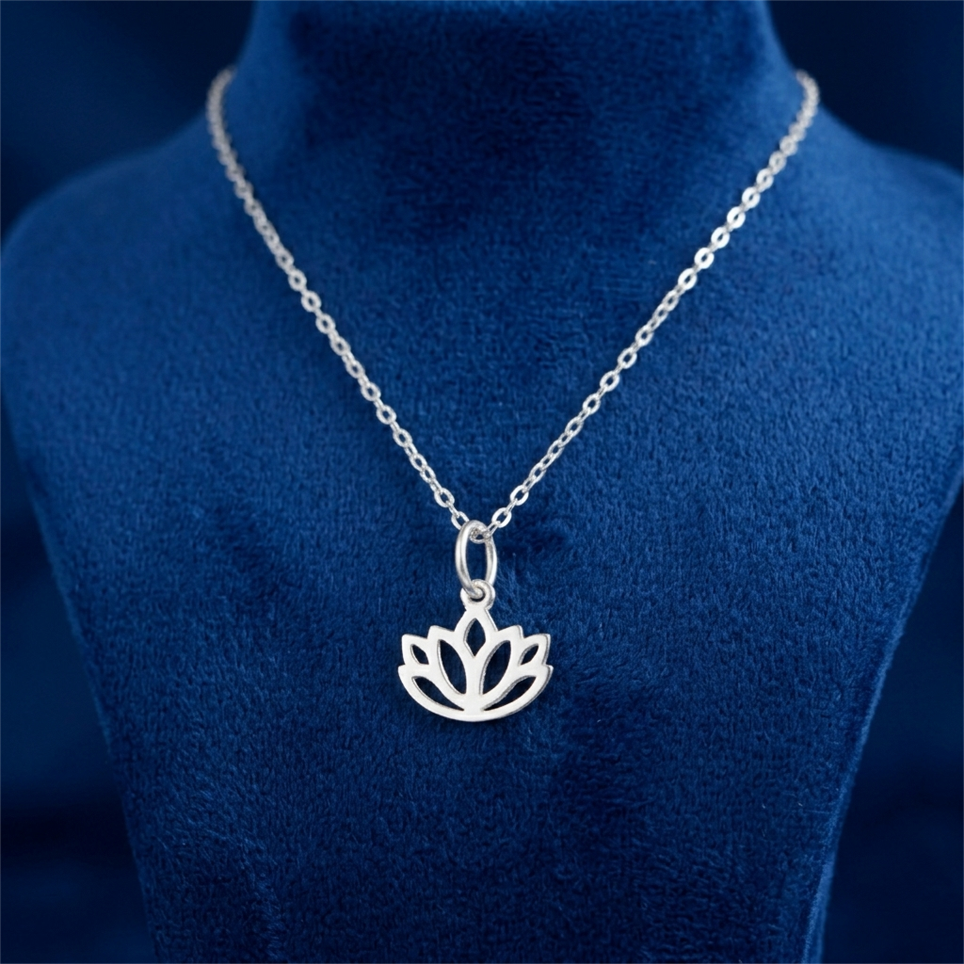 Silver-toned necklace with a single filigree lotus charm pendant at the center