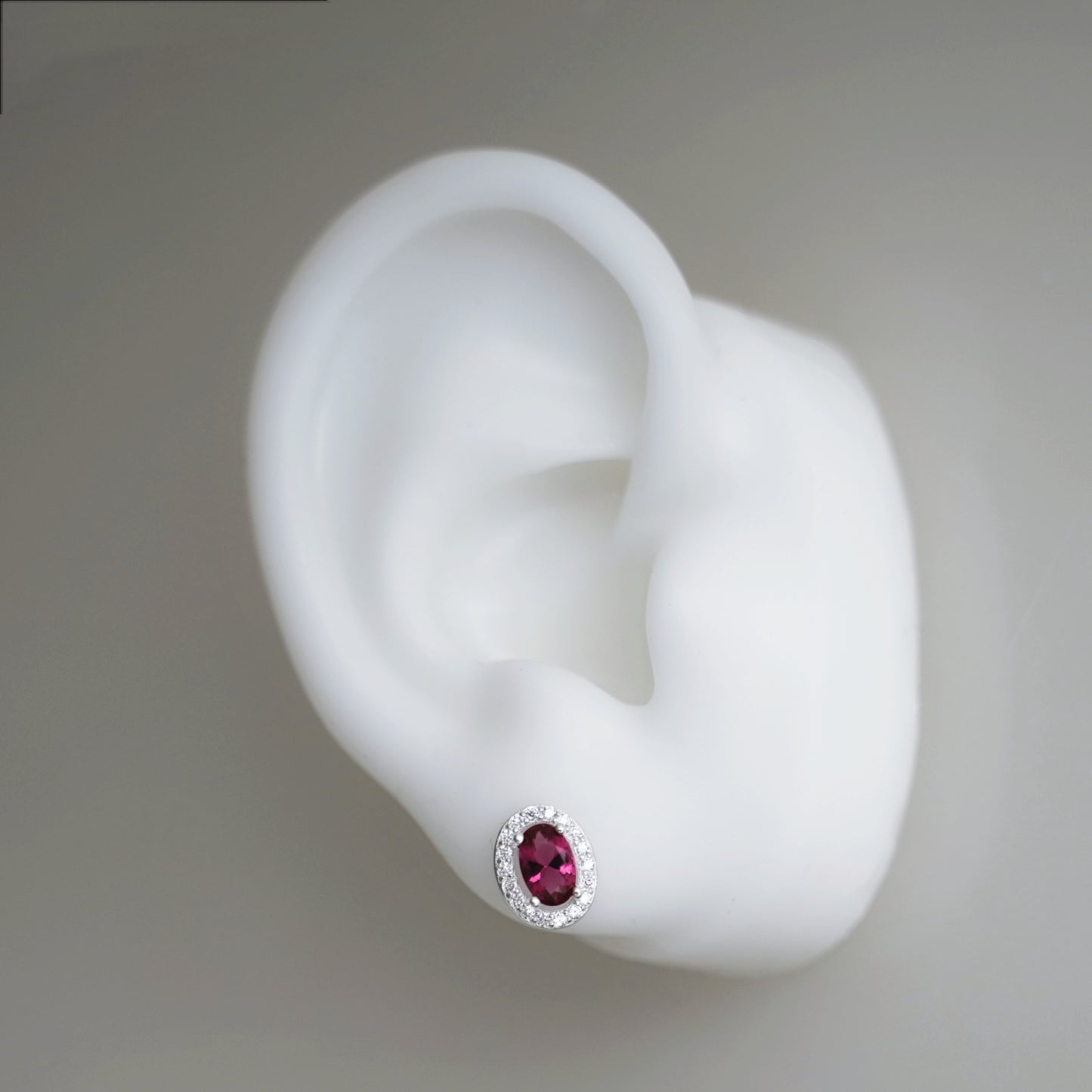 CZ halo stud earring, oval ruby red gem with silver crystal surround