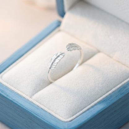 Open band ring with two feather-wing details, polished silvertone finish