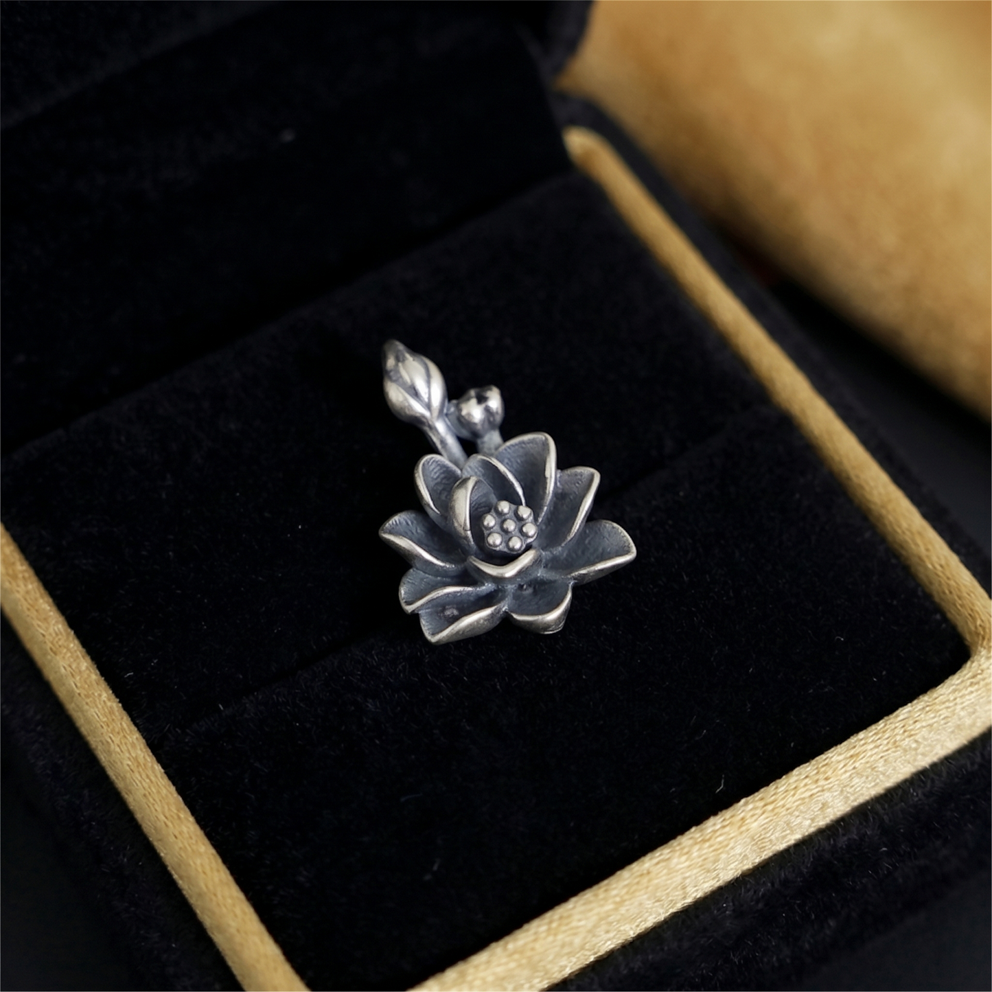 Oxidised 3D lotus pendant detail: dark petals with raised dots on center