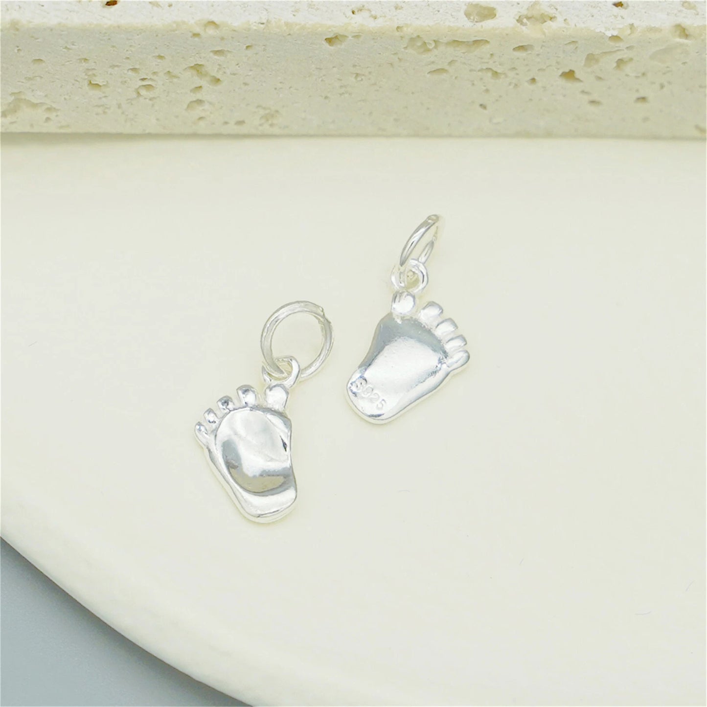 Silver baby foot charm pair with hanging loops and blue enamel sole details
