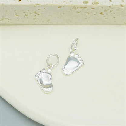 Silver baby foot charm pair with hanging loops and blue enamel sole details