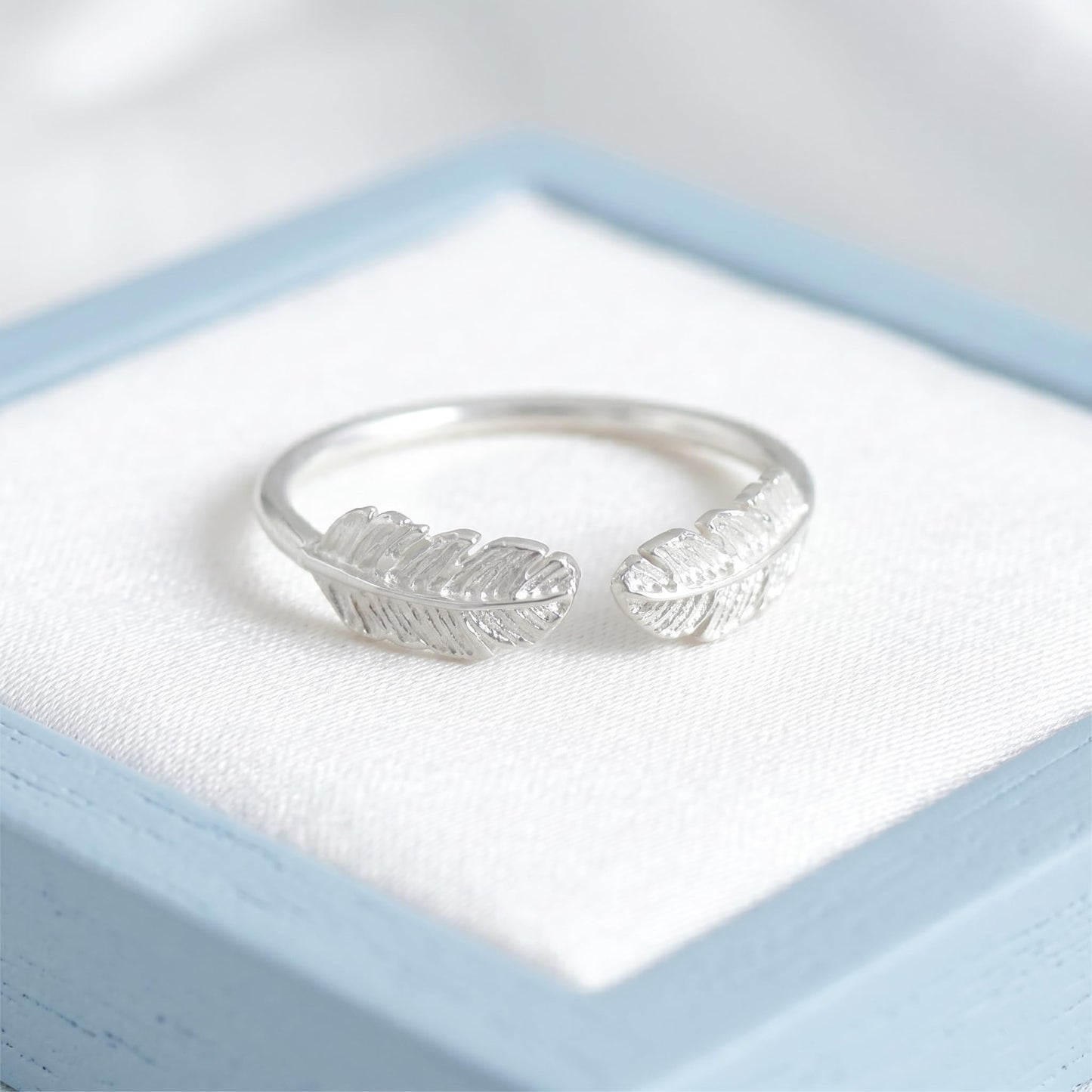 Silvertone open band ring with two embossed feather wings facing outward