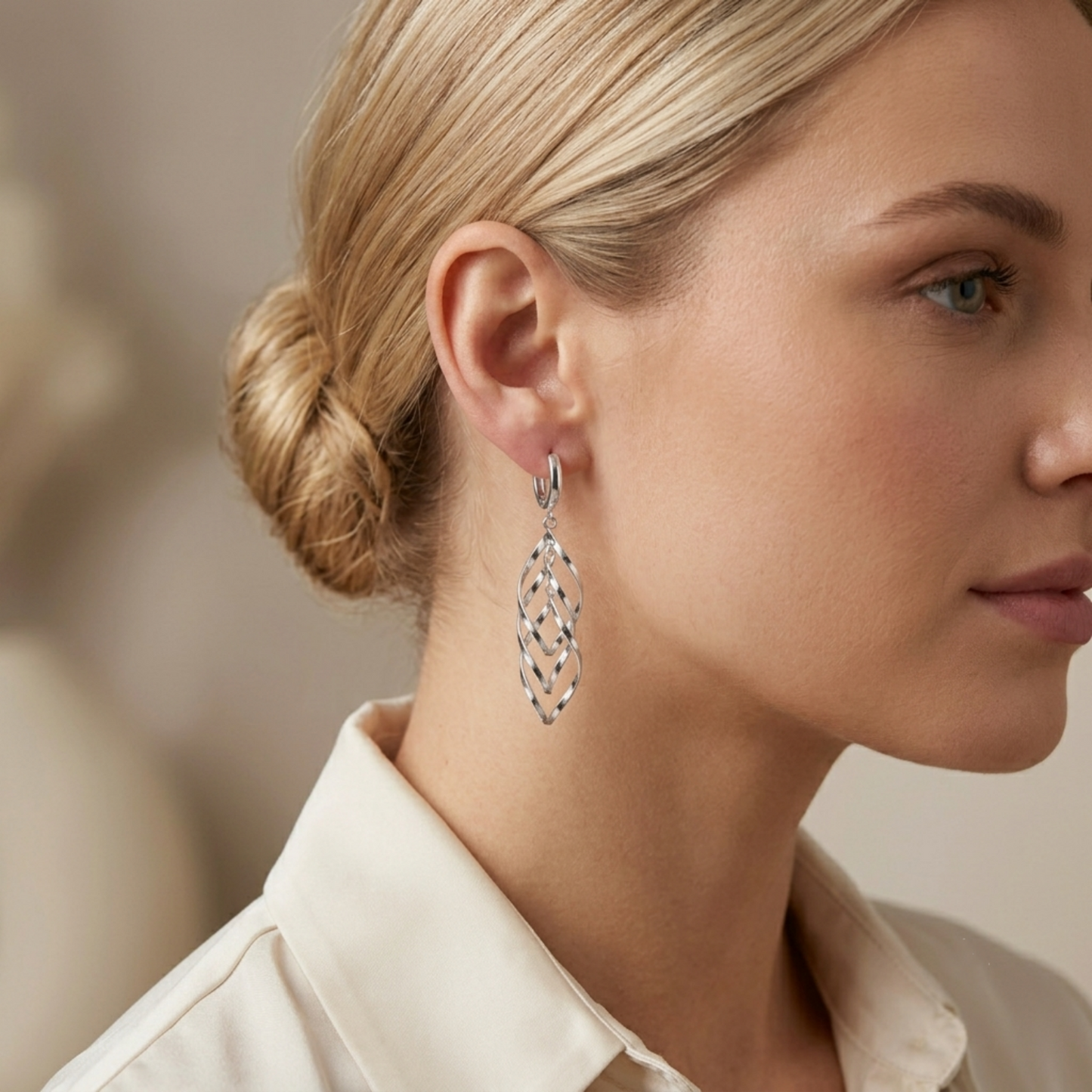 Silver-tone dangling hoop earrings with lattice drop, shown from side