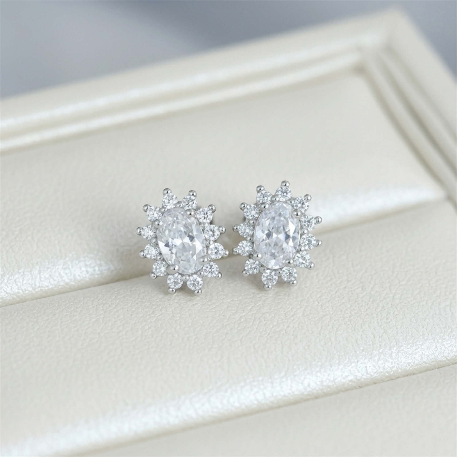 Clear oval gemstone cluster stud earrings with halo and small round accents