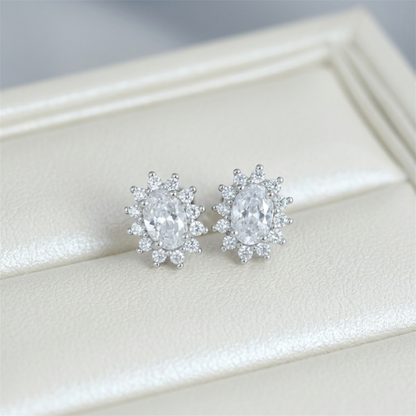 Clear oval gemstone cluster stud earrings with halo and small round accents