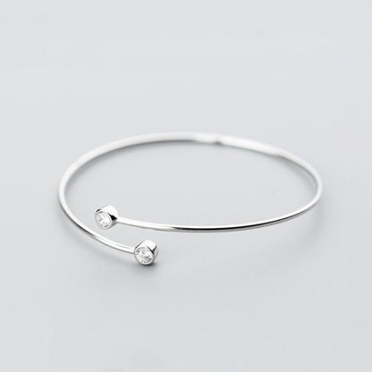 Silver-tone torque bangle with two round CZ stones spaced on the bar