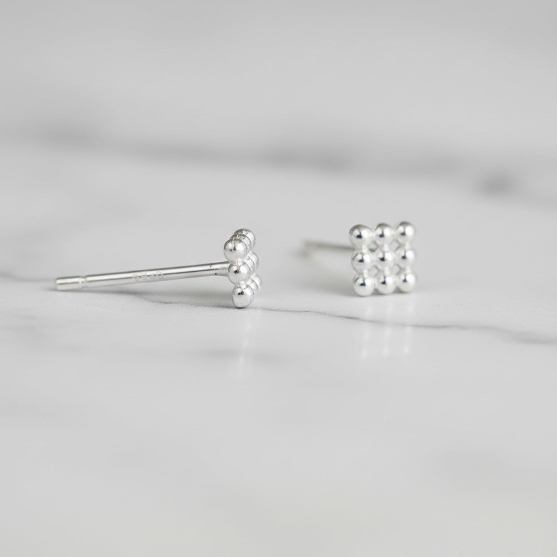 Mini geometric cube stud earrings, close-up with spherical bead details and post