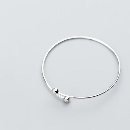Silver CZ torque bangle with two small round bezel-set stones