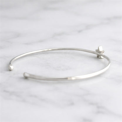 Silver-tone star torque bangle bracelet from side angle with star charm