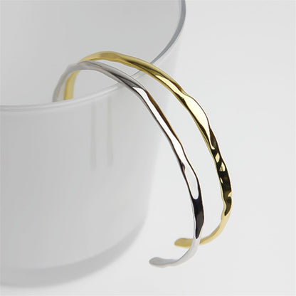 Hammered 18K gold cuff bracelet close-up on wrist opening edge