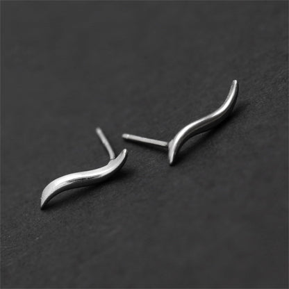 Wavy vine climber stud earrings, angled view of curved metal wave and earring post
