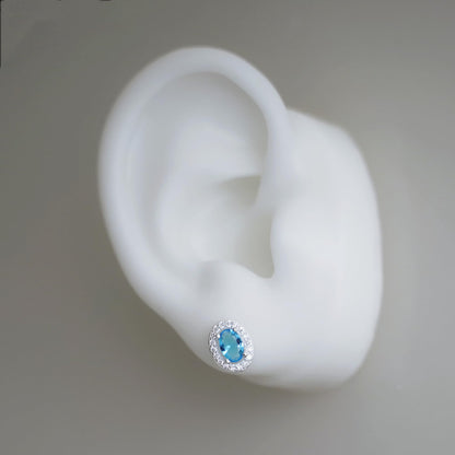 Single blue oval CZ halo stud earring in a silver-tone setting