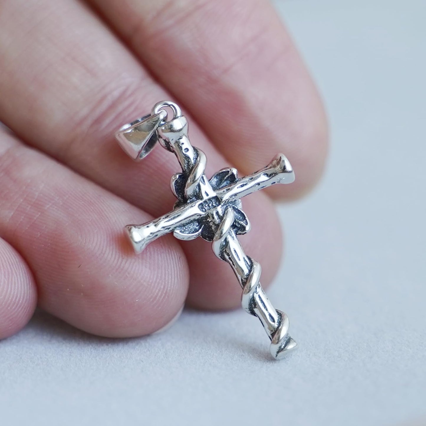 Oxidised Rose Thorn Cross pendant close-up on chain, cross arms with rose and thorn motifs