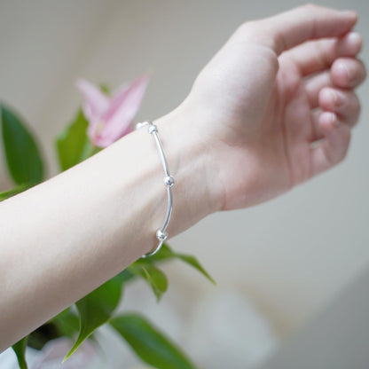 Silver bead stretch bracelet worn on wrist, close to hand