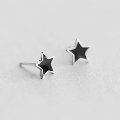 Black star stud earrings with silver posts extending from the back