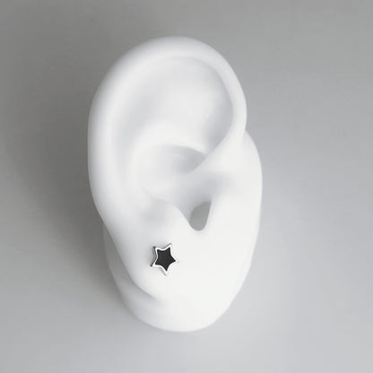 Side view of black star stud earring on a silver post