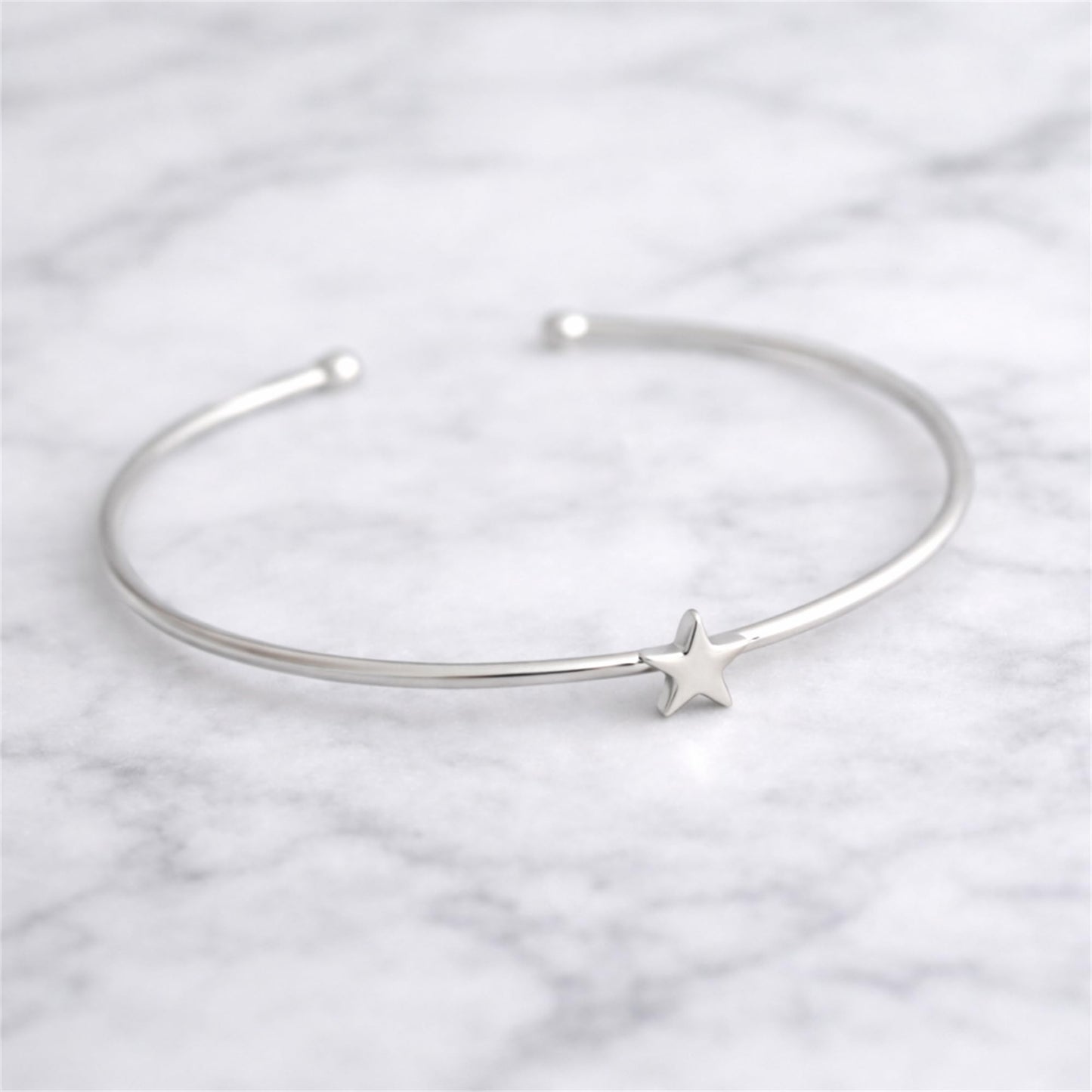 Silver-tone torque bangle bracelet with small star charm
