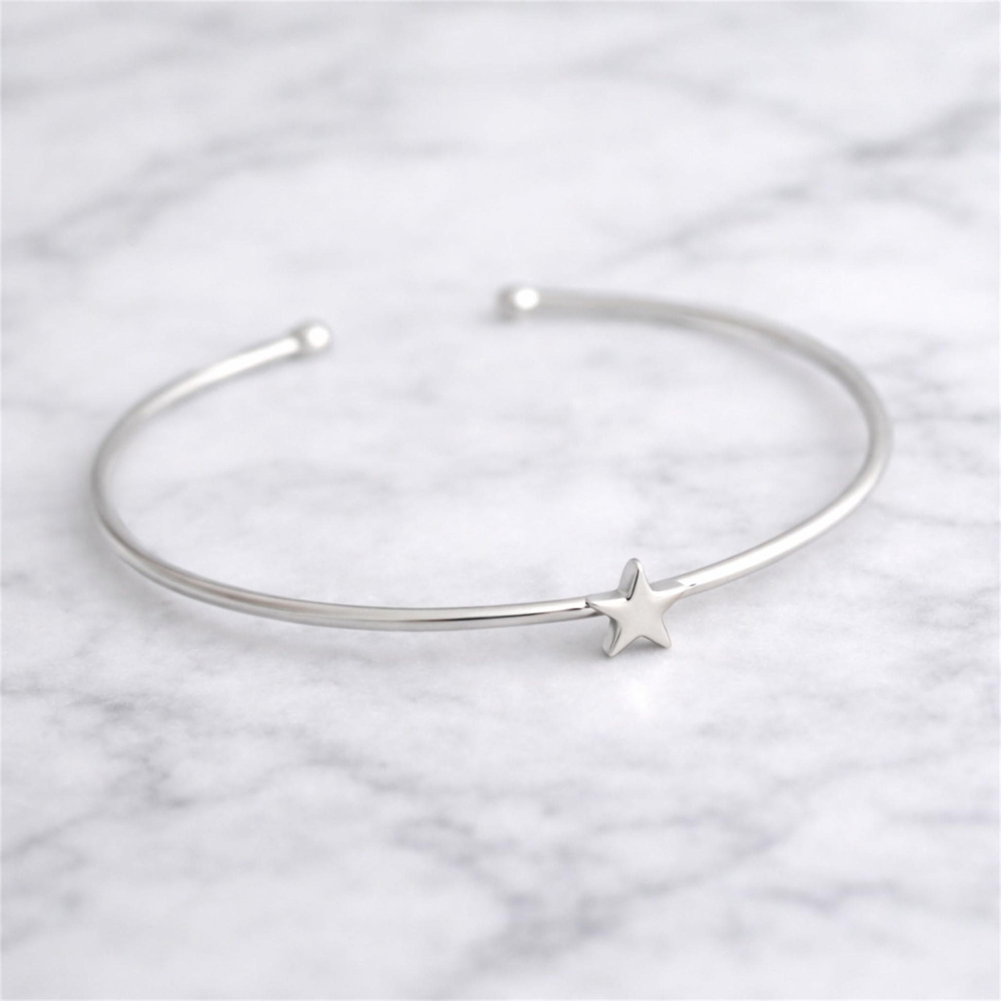 Silver-tone torque bangle bracelet with small star charm