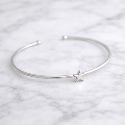 Silver-tone torque bangle bracelet with small star charm