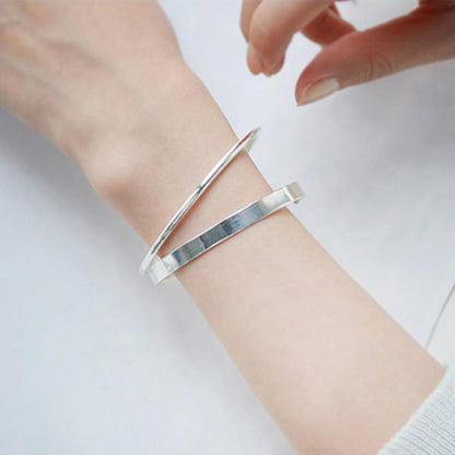 Polished cuff bangle on wrist with open cuff gap and reflective finish