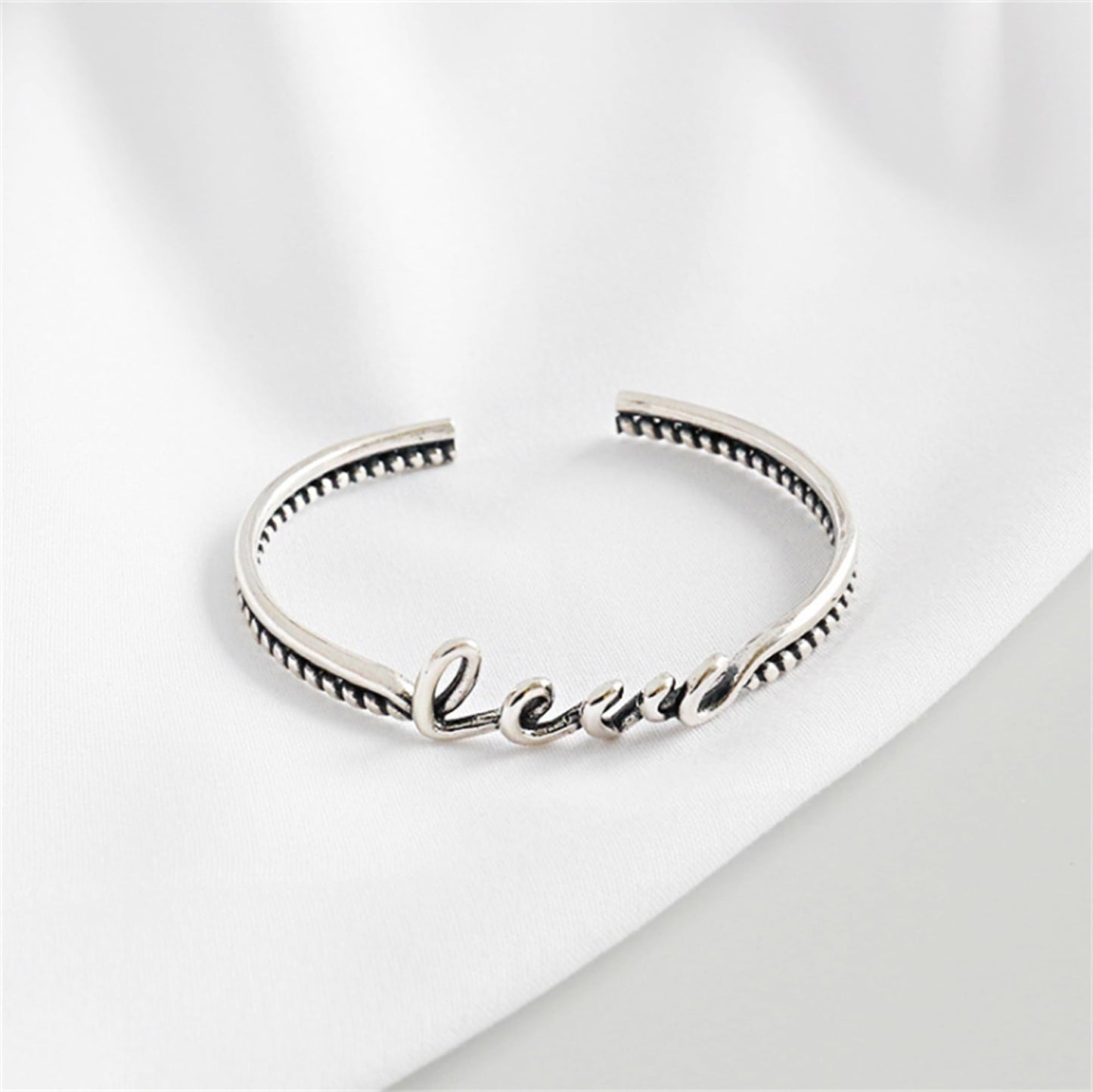 Love Knot Rope Cuff bracelet close-up of inner stamp and ridged edge, silver-tone