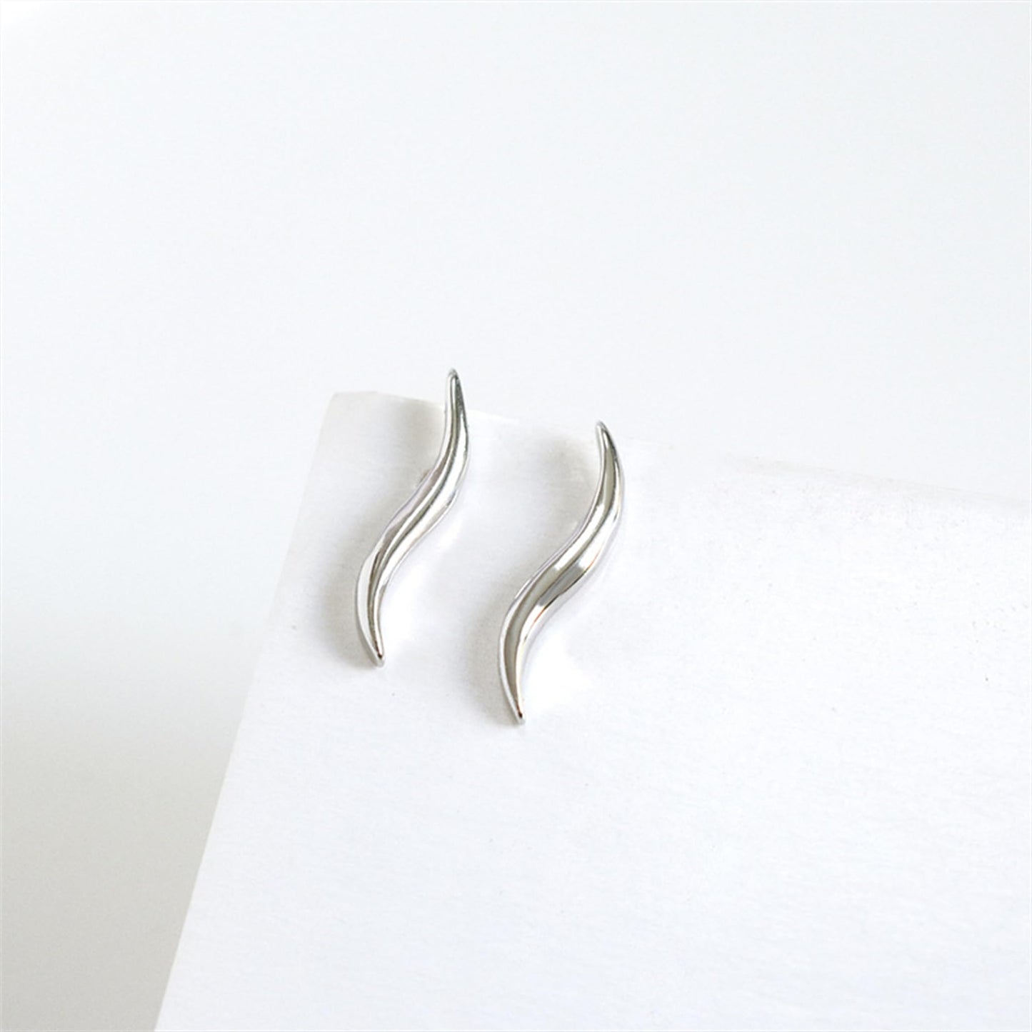 Wavy vine climber stud earrings, side view showing curved metal wave and post