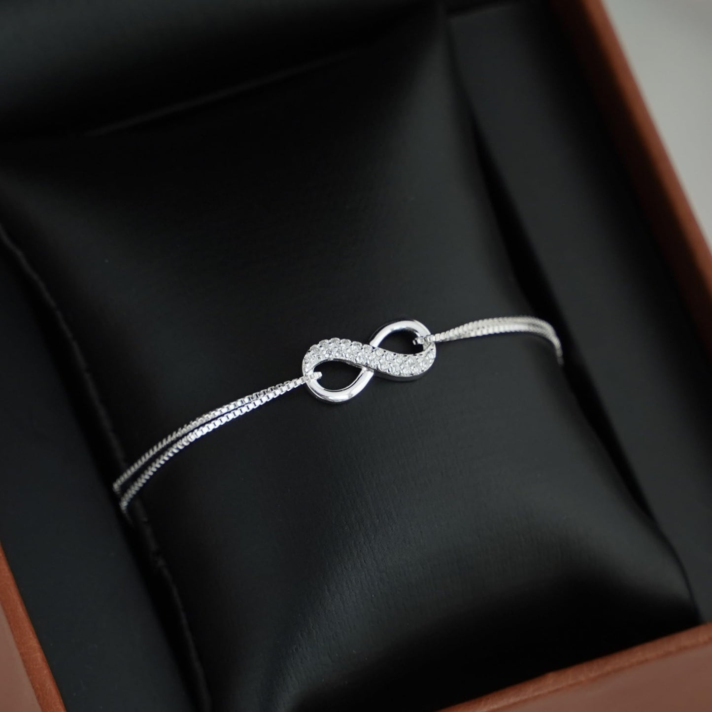 CZ Infinity bracelet detail: two oval loops with pavé-style textured infinity centerpiece