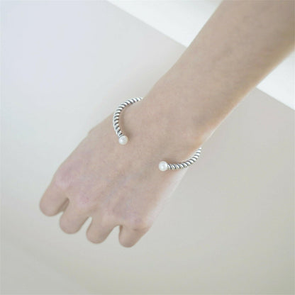Pearl Twisted Torque Bangle on hand wrist, silver twisted cuff with two white pearls