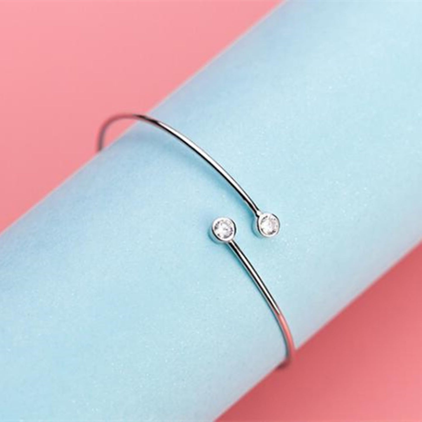 Torque bangle with two round CZ stones in bezel settings on silver band