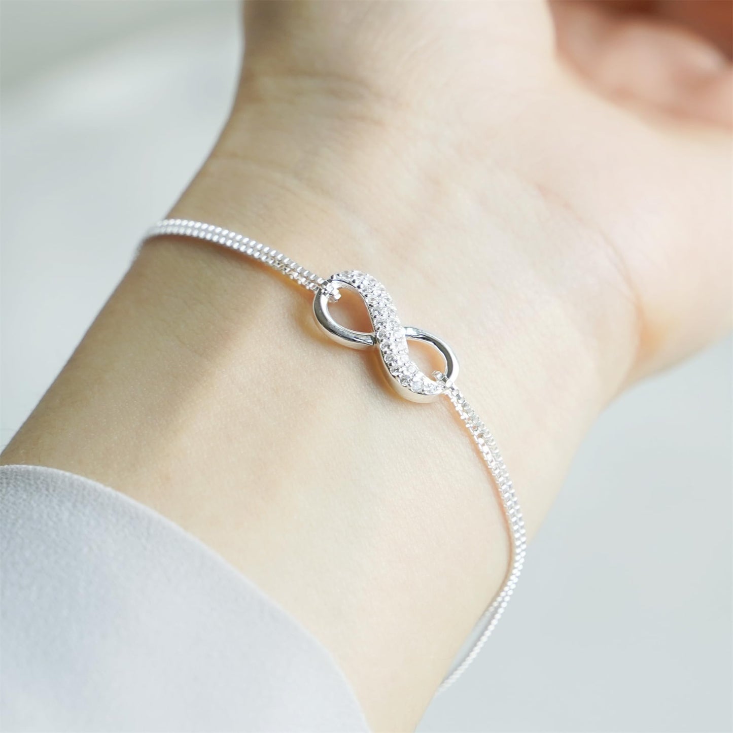 CZ Infinity bracelet close-up on wrist: sparkling infinity center with oval loops