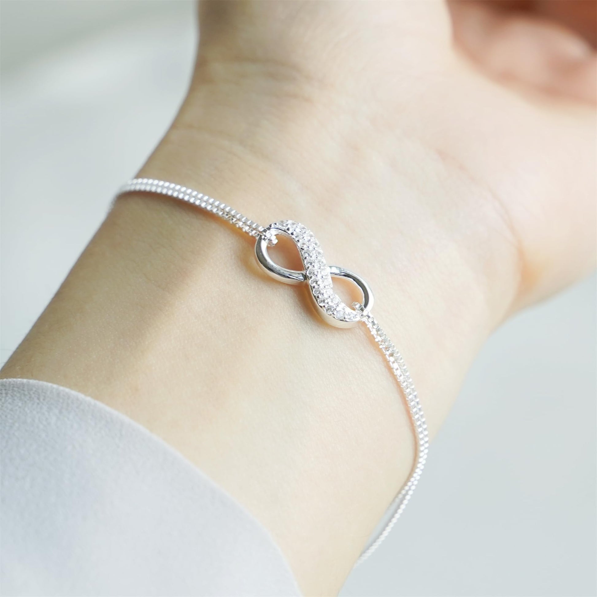 CZ Infinity bracelet close-up on wrist: sparkling infinity center with oval loops