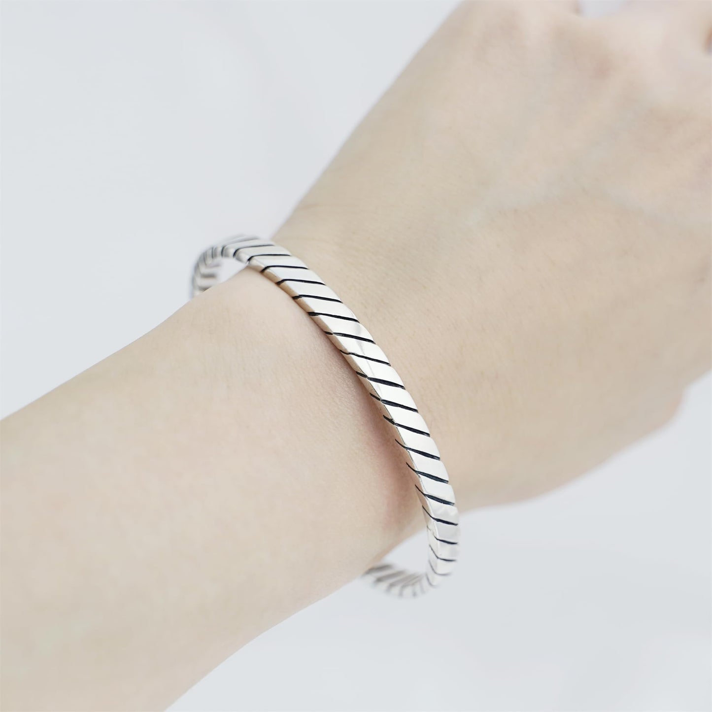 Oxidised rope cuff bangle worn on wrist, silver-tone ridged rope bracelet look