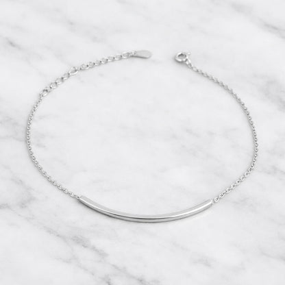 Curved Tube Curb Anklet featuring curved metal tube bar and curb chain with clasp