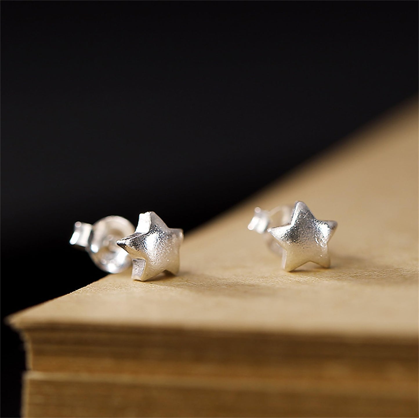 Puffy Star Studs auf Holzunterlage: silberfarbene Stern-Ohrstecker