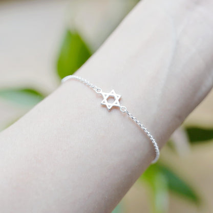 Silver Star of David bracelet worn on wrist with star charm on chain.