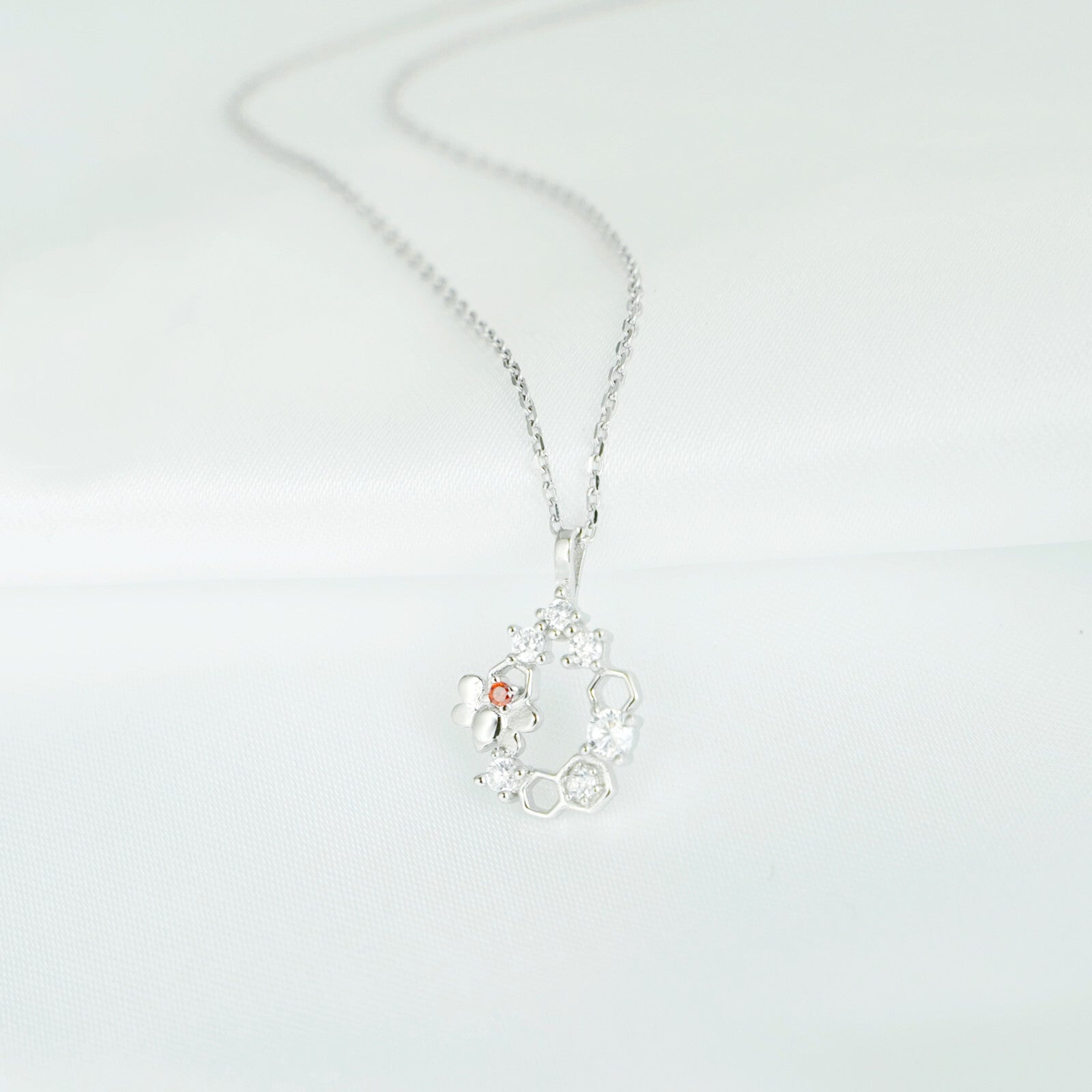 Silver-tone honeycomb necklace pendant with bee and sparkling hexagon charms