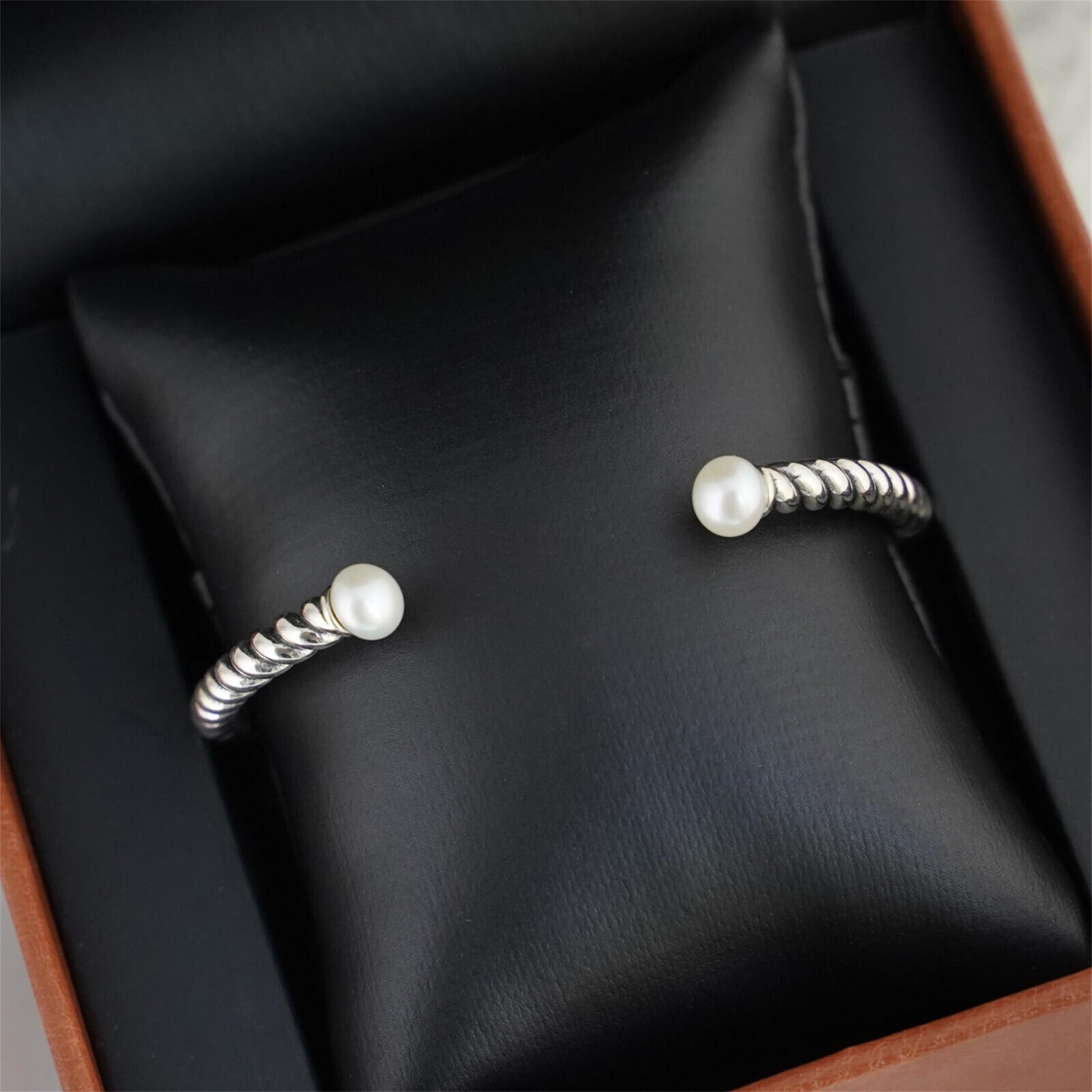 Pearl Twisted Torque Bangle on black display: pearl tips on twisted silver wire