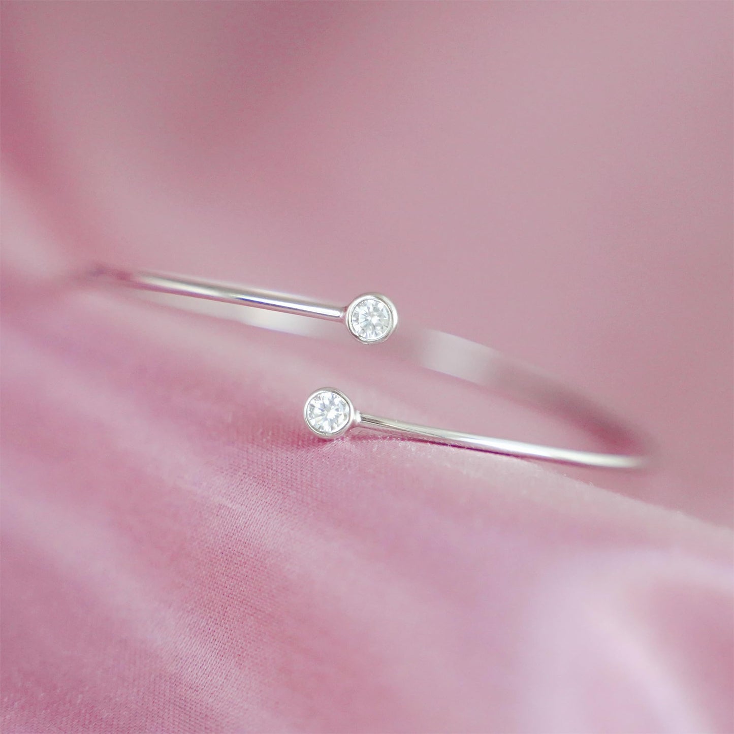 Close-up of silver CZ torque bangle with round bezel-set stones