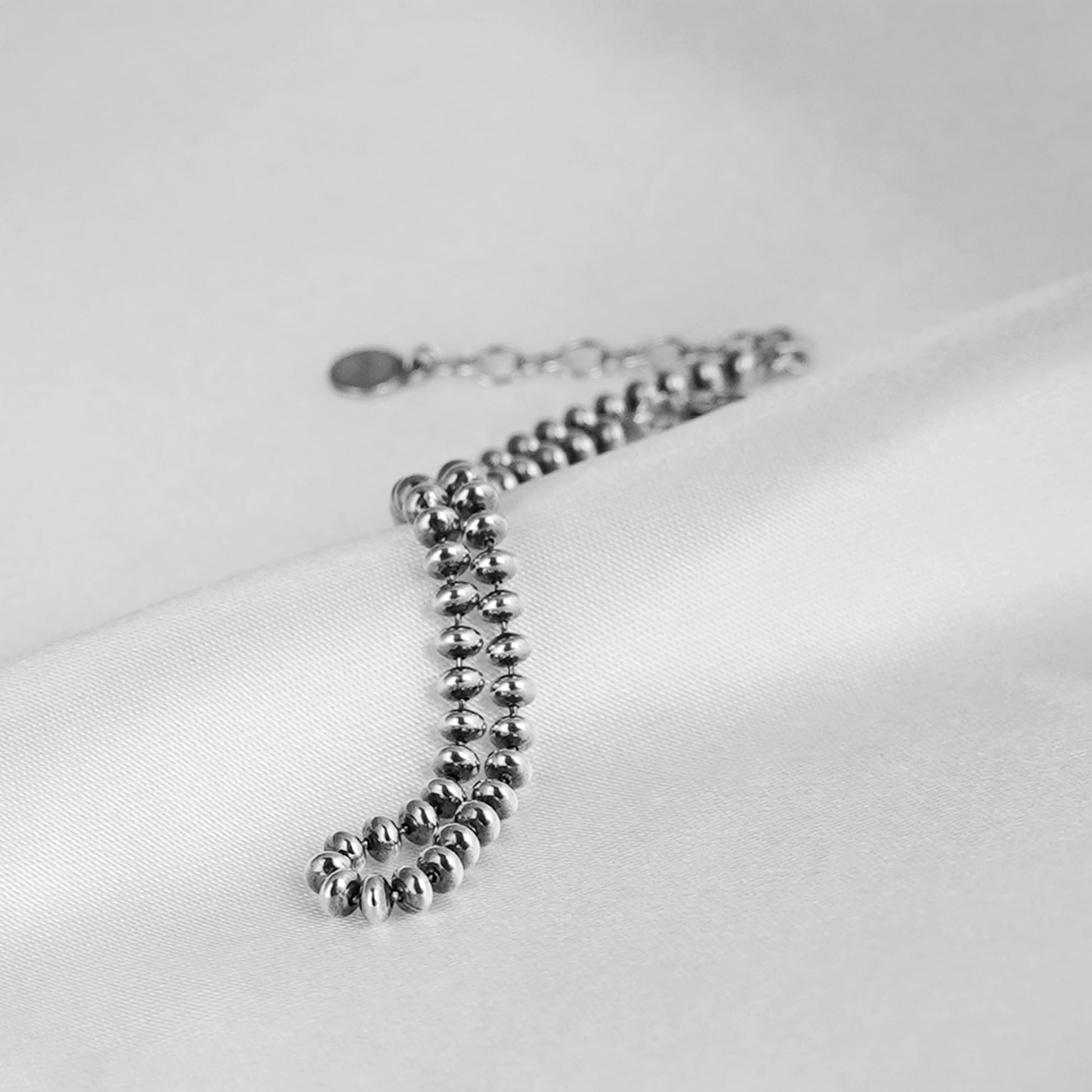 Oxidised flat bead bracelet angled view—silver-toned round beads with small clasp