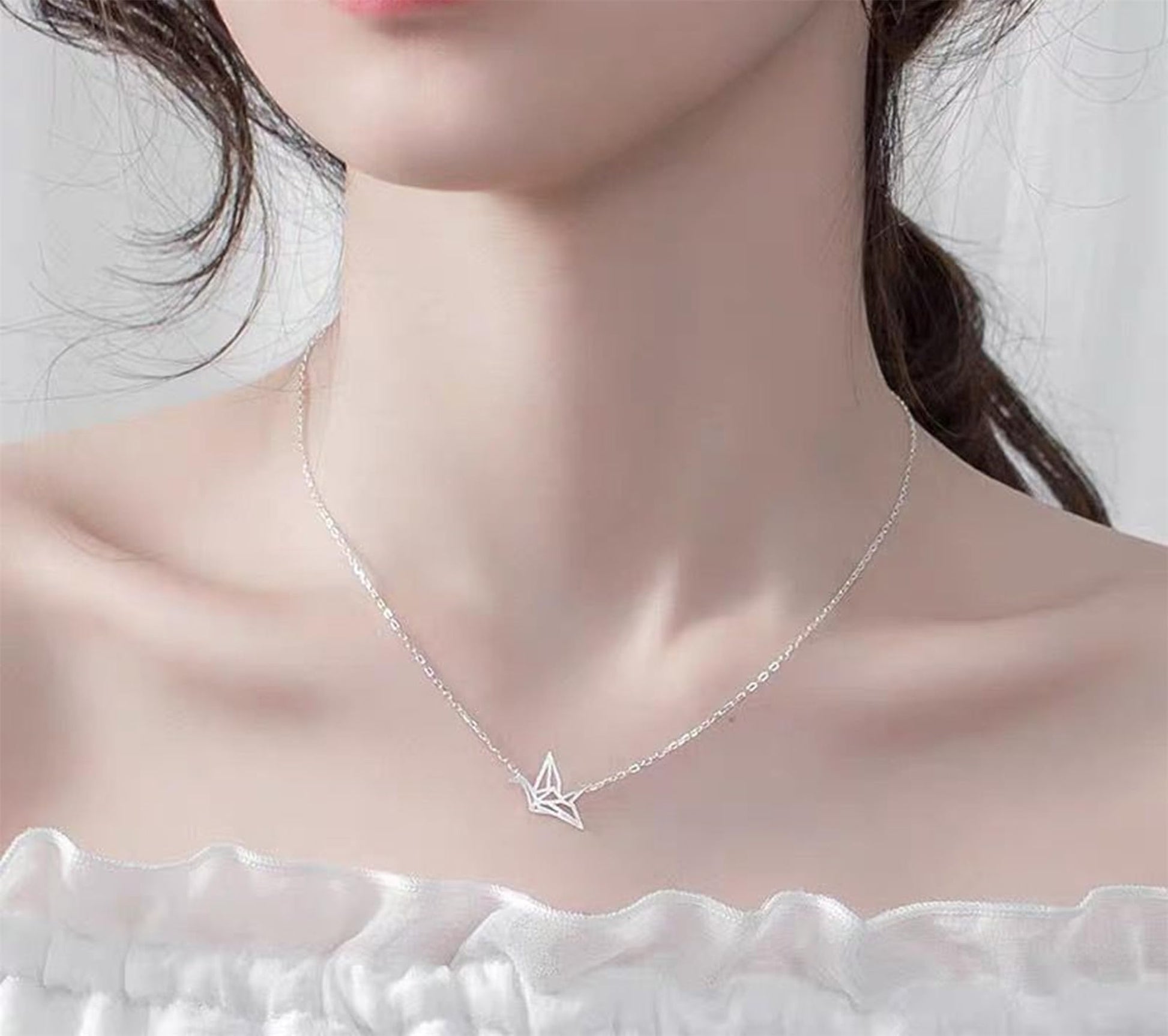 Origami crane necklace on model with silver chain and crane charm
