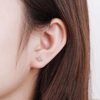 Mini geometric stud earrings on ear: cube design with small bead cluster