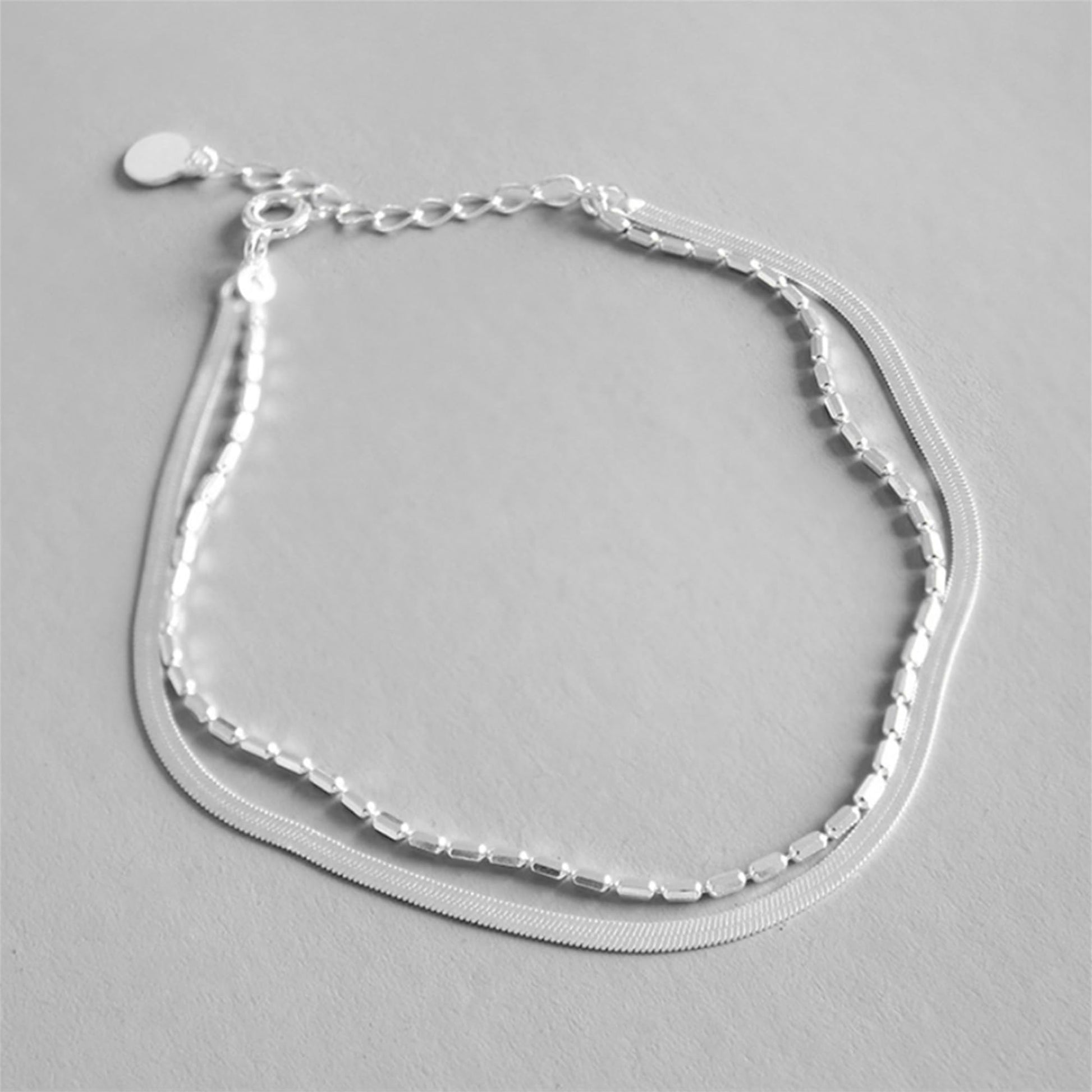 Layered snake bead bracelet with three chain layers and curved mesh strand