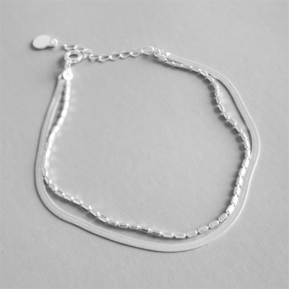 Layered snake bead bracelet with three chain layers and curved mesh strand