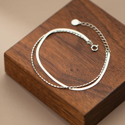 Layered snake bead bracelet with smooth curved chain and link chain layers
